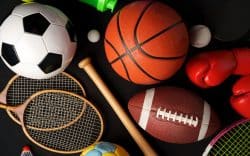 Attrezzatura sportiva varia tra cui pallone da calcio, basket, racchette e guantoni