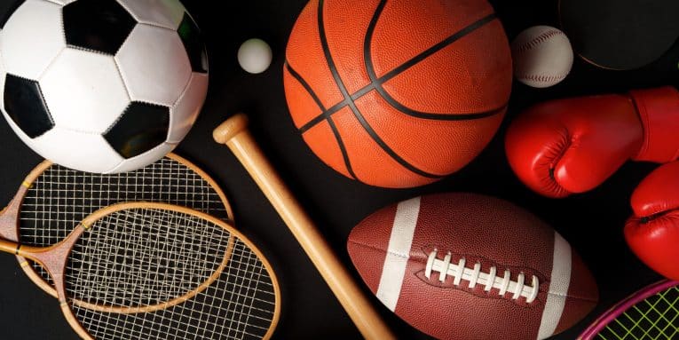 Attrezzatura sportiva varia tra cui pallone da calcio, basket, racchette e guantoni