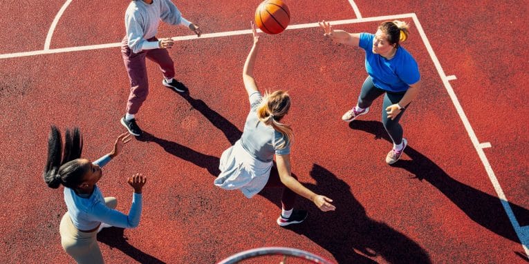 Gruppo di ragazze che giocano a basket all’aperto