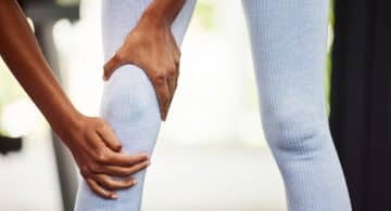 Persona che si tiene il ginocchio a causa di un dolore