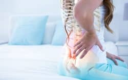 Persona con colonna vertebrale evidenziata e dolore nella zona lombare