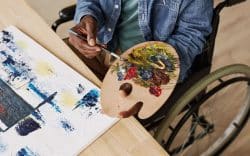 Persona in sedia a rotelle che dipinge