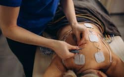 Persona sdraiata con elettrodi applicati sulla schiena