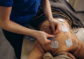 Persona sdraiata con elettrodi applicati sulla schiena