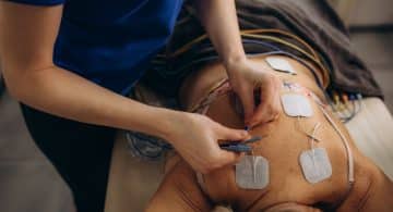 Persona sdraiata con elettrodi applicati sulla schiena