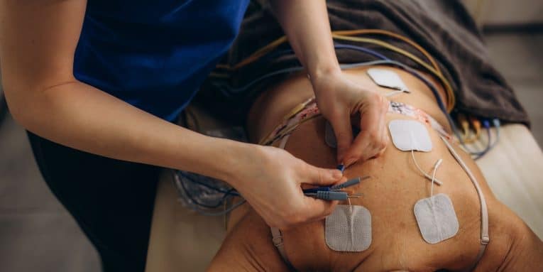Persona sdraiata con elettrodi applicati sulla schiena