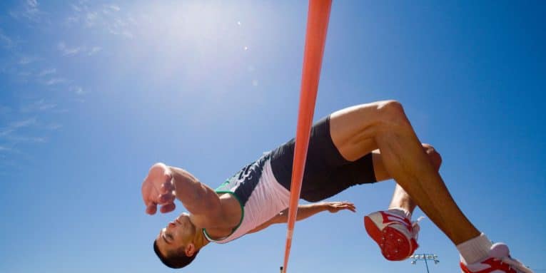Persona che salta sopra un’asta durante un salto in alto