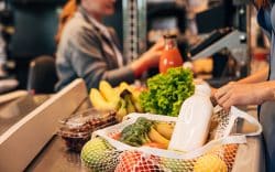 Borsa con spesa in rete appoggiata su una cassa al supermercato