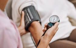 Misurazione della pressione con bracciale sul braccio e manometro in mano