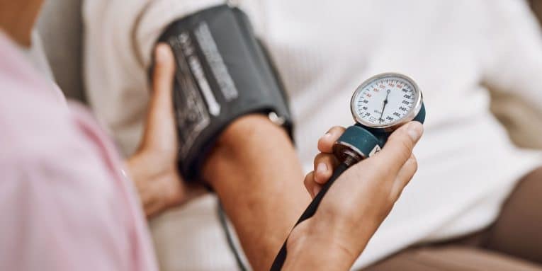 Misurazione della pressione con bracciale sul braccio e manometro in mano