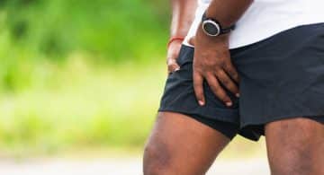 Sportivo che si tiene la coscia per dolore