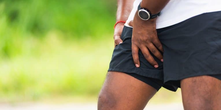Sportivo che si tiene la coscia per dolore