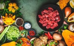 iotola con pezzi di carne cruda circondata da verdure crude e spezie