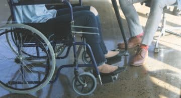 Persona in sedia a rotelle di fronte a un’altra persona seduta