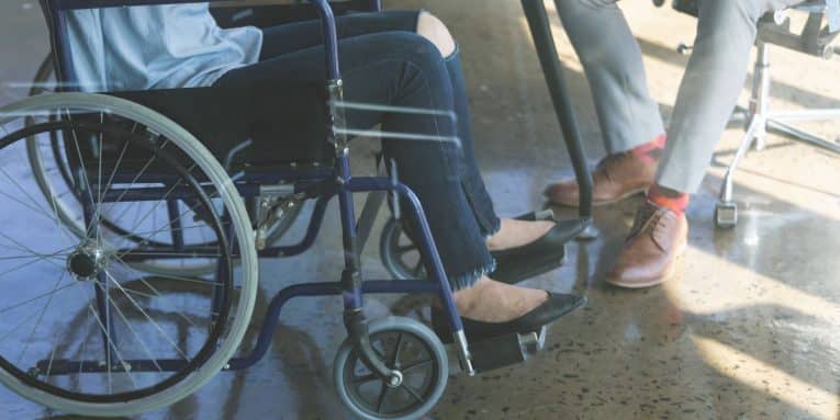 Persona in sedia a rotelle di fronte a un’altra persona seduta