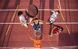 Vista dall’alto di giocatori di basket mentre tirano a canestro su un campo sportivo