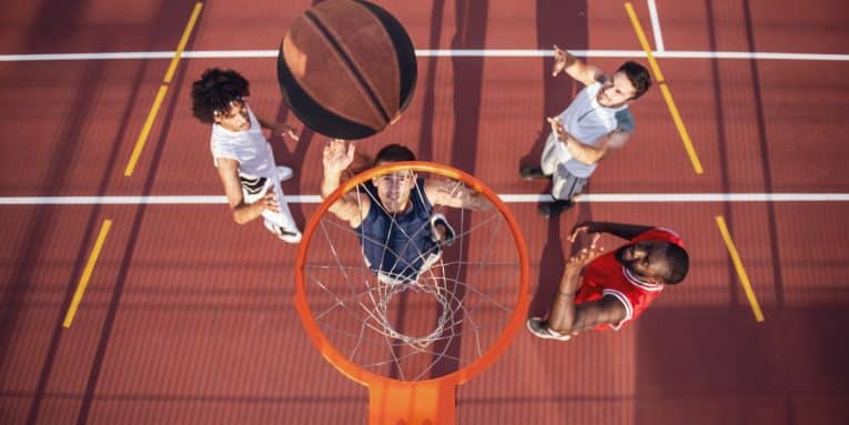 Vista dall’alto di giocatori di basket mentre tirano a canestro su un campo sportivo