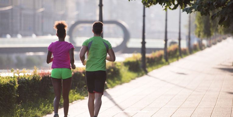 Due persone che corrono su un percorso urbano all’aperto