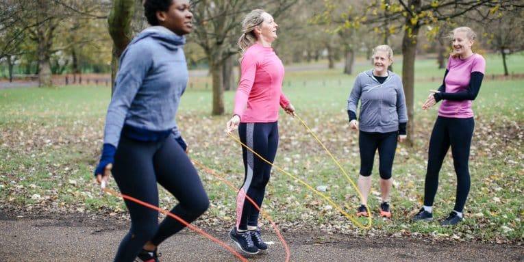 Gruppo di donne che salta la corda all’aperto in un parco
