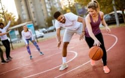 Persone che giocano a basket su campo all’aperto