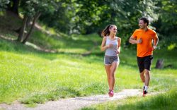 Uomo e donna che corrono insieme su sentiero sterrato