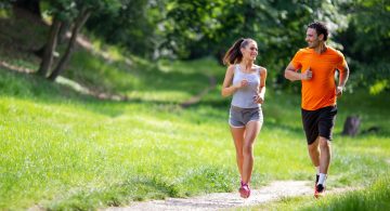 Uomo e donna che corrono insieme su sentiero sterrato