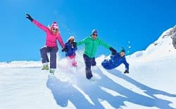 Persone che giocano e corrono sulla neve in montagna