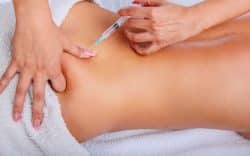 iniezione nella parte bassa della schiena con siringa su persona sdraiata