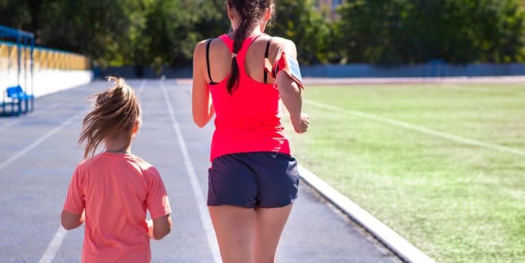 donna e bambina che corrono su pista di atletica