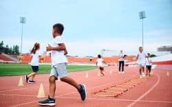 gruppo di bambini durante attività sportiva su pista di atletica