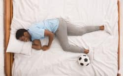 persona sdraiata su un letto con un pallone accanto