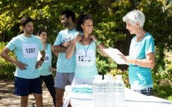 gruppo di persone con pettorine numerate mentre una persona tiene una cartellina