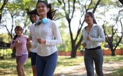 persone che corrono in un parco con abbigliamento sportivo