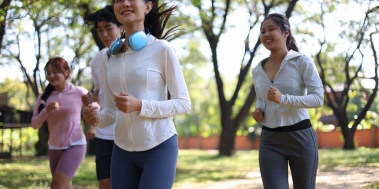 persone che corrono in un parco con abbigliamento sportivo