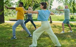 gruppo di persone con abbigliamento sportivo mentre fanno Tai Chi in un parco