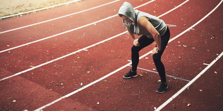 donna dopo la corsa su pista atletica si ferma affaticata