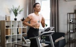 donna si allena su tapis roulant in casa