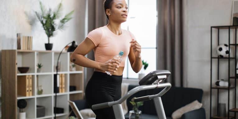 donna si allena su tapis roulant in casa