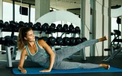 persona con abbigliamento sportivo mentre esegue esercizi a terra per le gambe in palestra