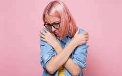 donna con dolore tiene le braccia incrociate mostrando disagio