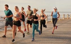gruppo di persone corre sul lungomare