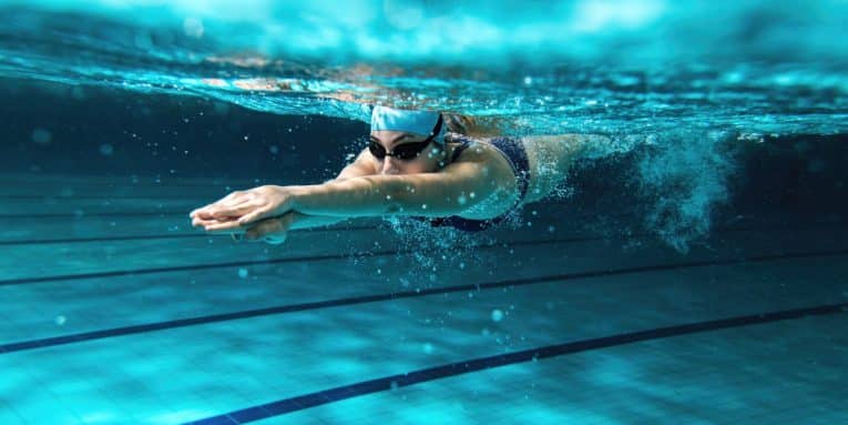 Persona che nuota sott’acqua in una piscina.