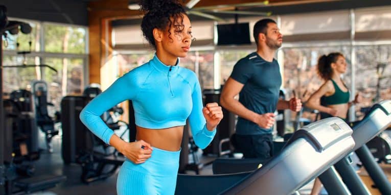 Persone che corrono sui tapis roulant in palestra.