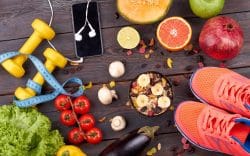 alimenti e attrezzatura sportiva disposti su un tavolo in legno.