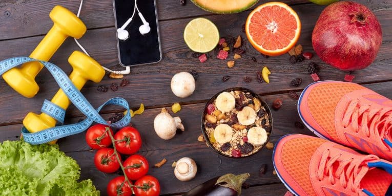 alimenti e attrezzatura sportiva disposti su un tavolo in legno.