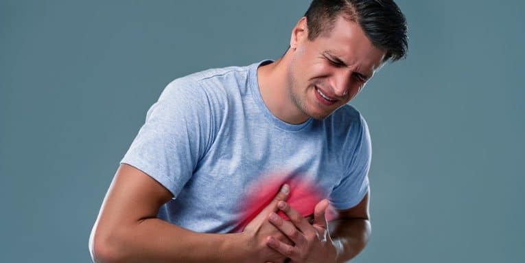 Uomo che si tiene il petto con espressione dolorante