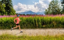 Donna che corre lungo un sentiero di campagna immerso nella natura