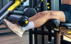 Persona che si allena in palestra con una macchina per esercizi alle gambe