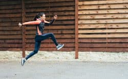 Donna esegue un salto durante la corsa all’aperto