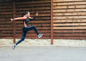 Donna esegue un salto durante la corsa all’aperto